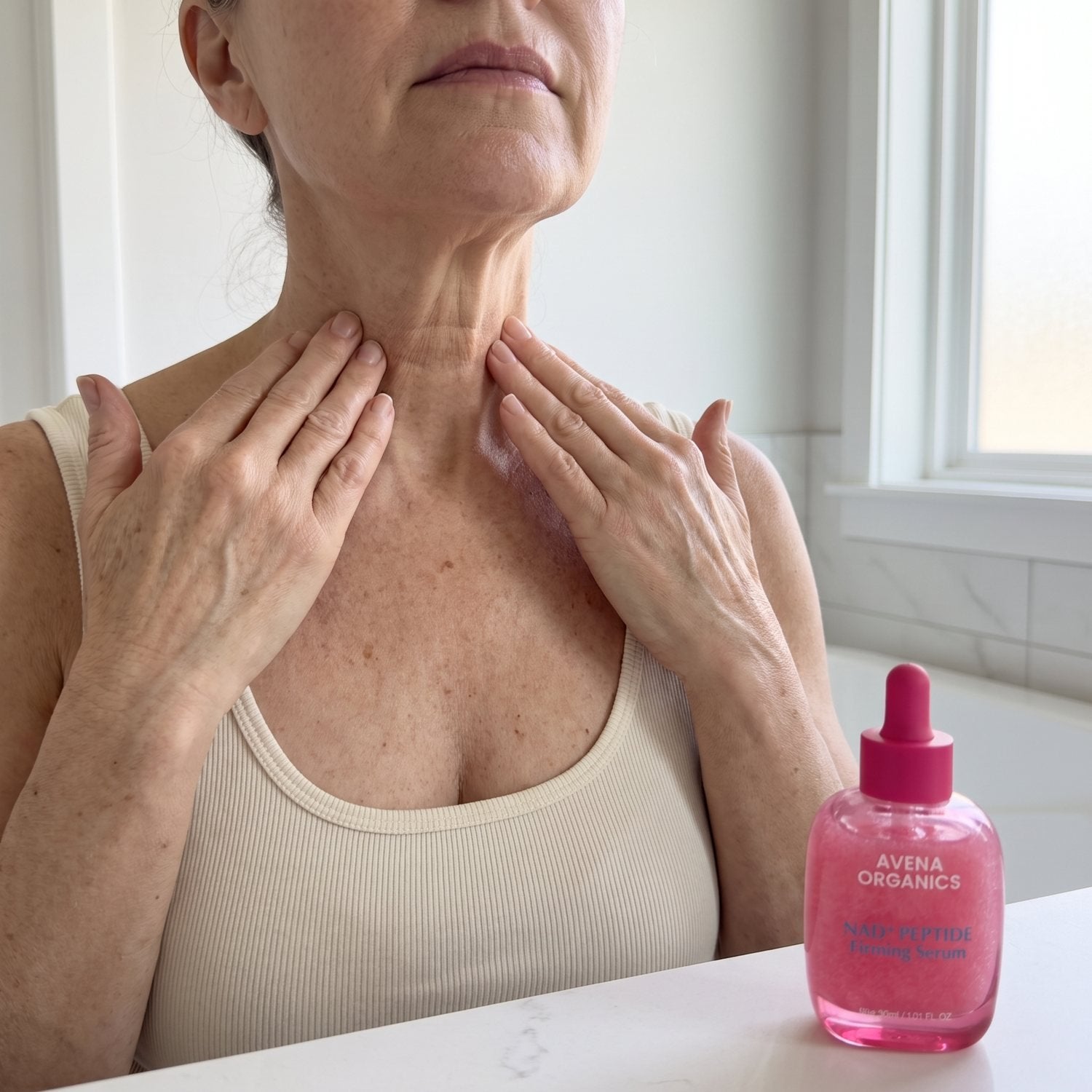 A woman sweeping the serum up her neck from the collarbone