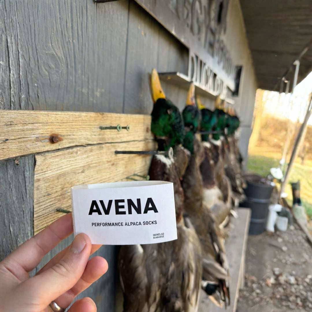 Hand holding the Avena alpaca compression sock packaging band