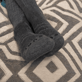 Existing customer photo of grey Avena socks on a patterned rug