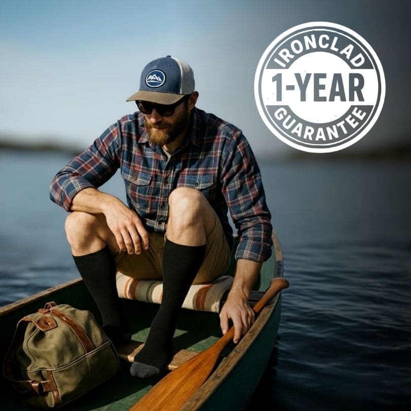 Man in a canoe wearing compression socks, 1-year guarantee badge