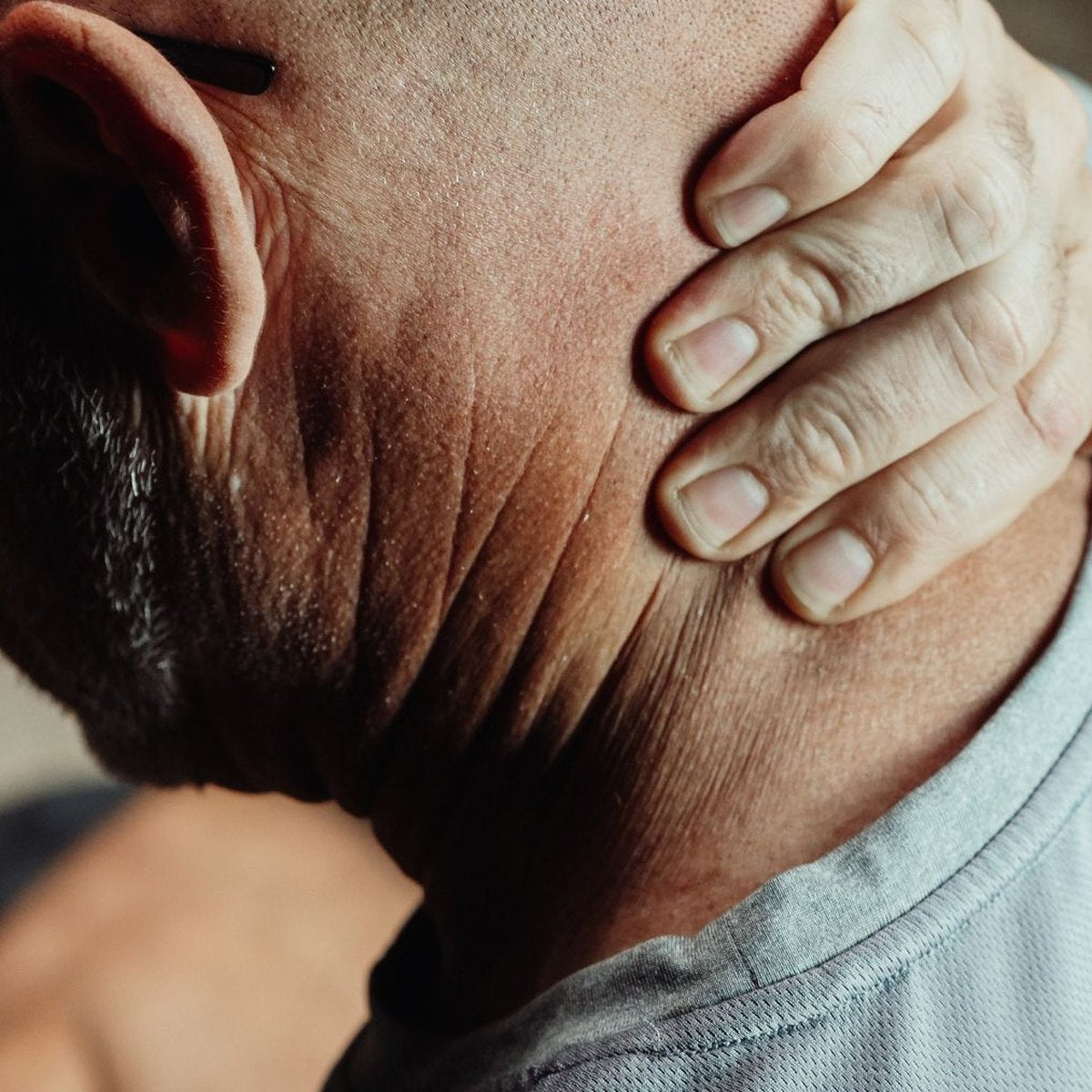 Man holding the back of his stiff neck